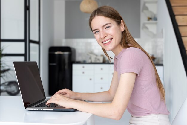 Donna di vista laterale che lavora al suo computer portatile