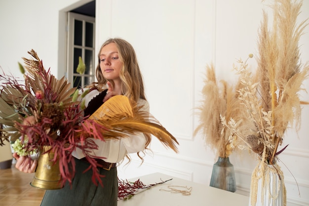 Donna di vista laterale che lavora con i fiori