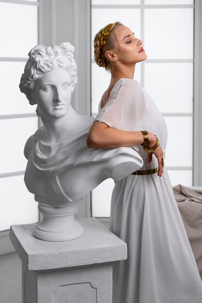 Donna di vista laterale che posa con la statua
