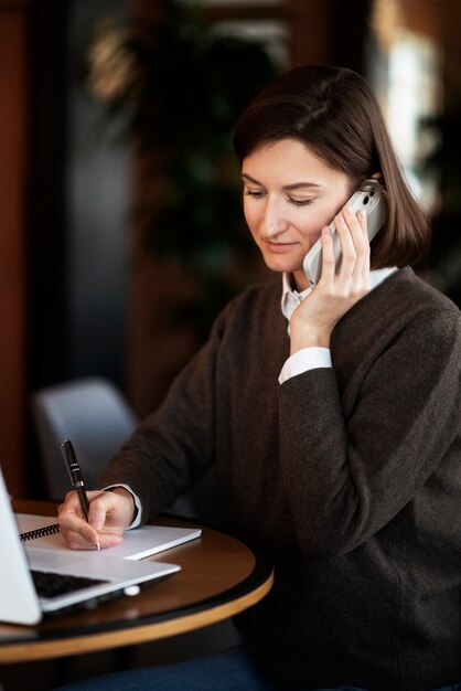 Donna di vista laterale che prende appunti