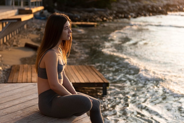 Donna di vista laterale che si distende sulla spiaggia