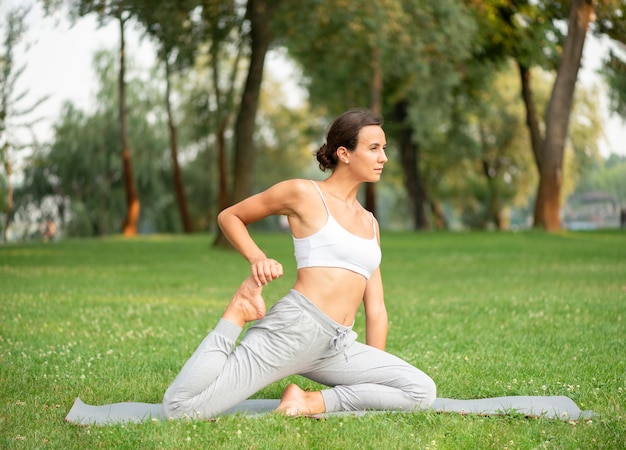 Donna di vista laterale che si esercita sulla stuoia di yoga