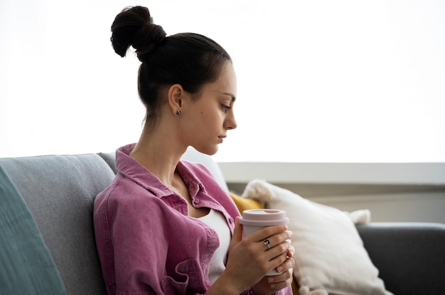 Donna di vista laterale che tiene tazza di caffè