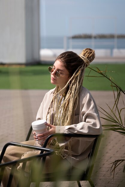 Donna di vista laterale che tiene tazza di caffè