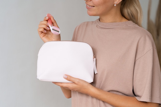 Donna di vista laterale che utilizza la borsa da toilette