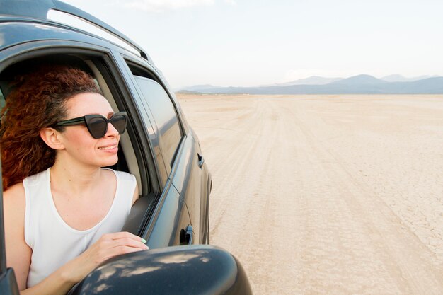 Donna di vista laterale che viaggia con l'automobile