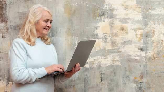 Donna di vista laterale con il computer portatile a casa