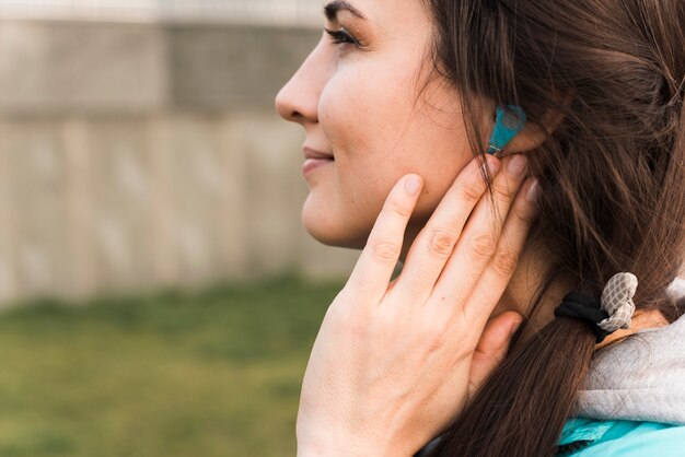 Donna di vista laterale in abiti sportivi che ascolta la musica