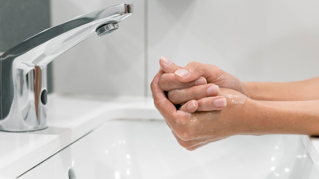 Donna di vista laterale lavarsi le mani