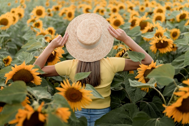 Donna di vista posteriore che posa con il cappello