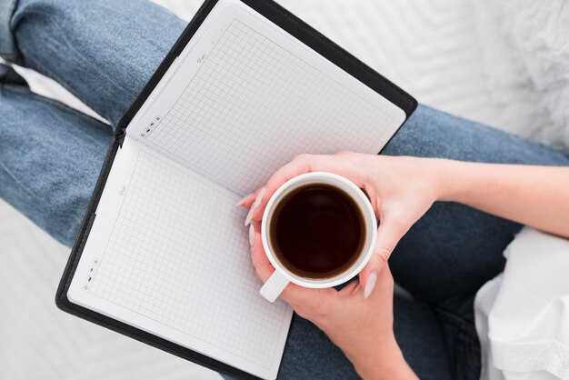 Donna di vista superiore che tiene una tazza di caffè