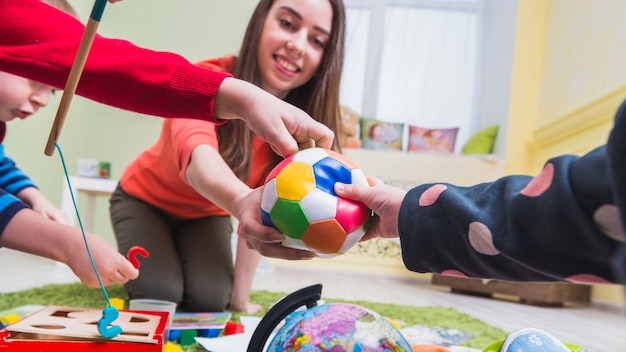 Donna e bambini che giocano sul pavimento