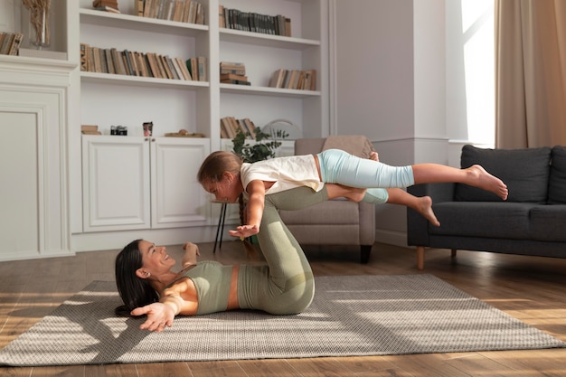 Donna e bambino a tutto campo che fanno yoga