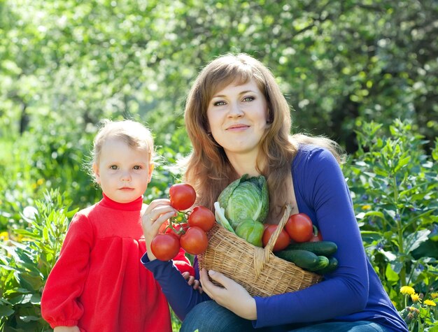Donna e bambino con raccolto di verdure