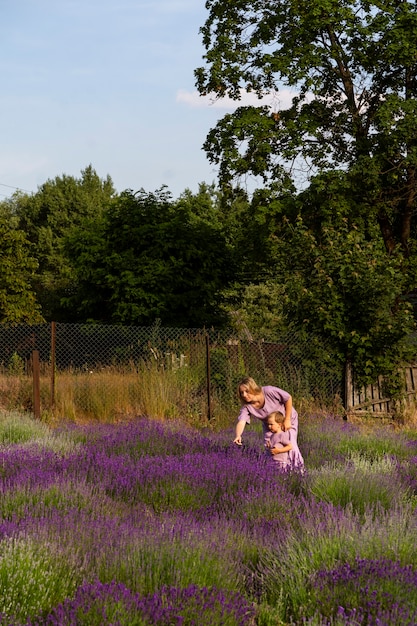 Donna e bambino del tiro lungo nel campo di lavanda