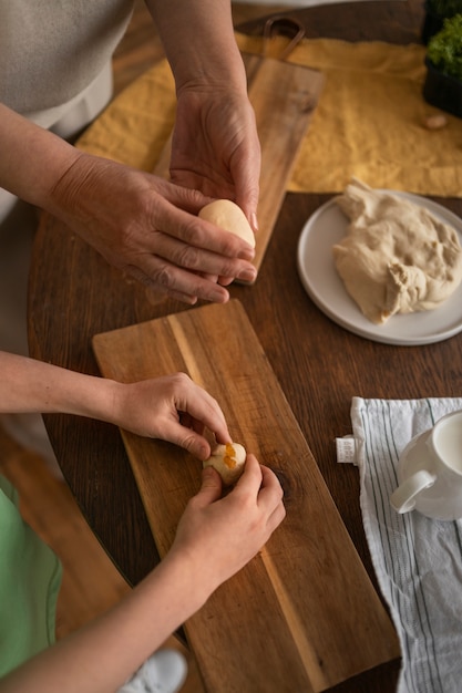 Donna e bambino dell'angolo alto che preparano alimento