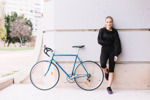 Donna e bicicletta vicino alla colonna