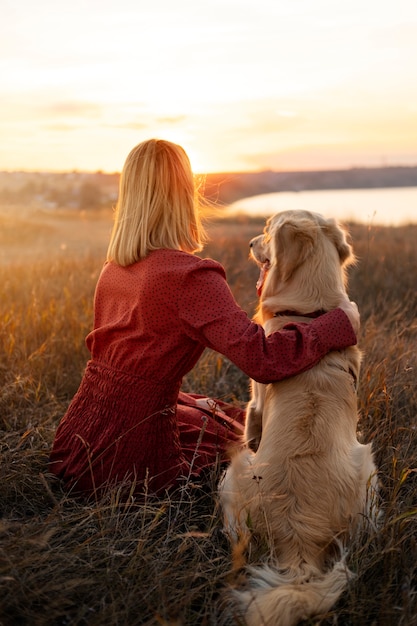 Donna e cane a tutto campo al tramonto