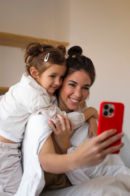 Donna e ragazza del tiro medio che prendono selfie