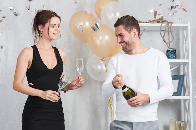 Donna e uomo che si preparano per bere champagne