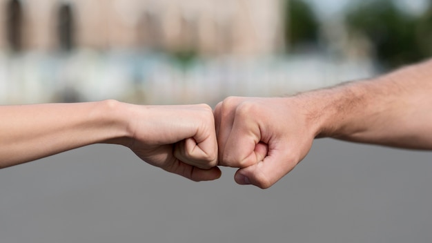 Donna e uomo che toccano i pugni