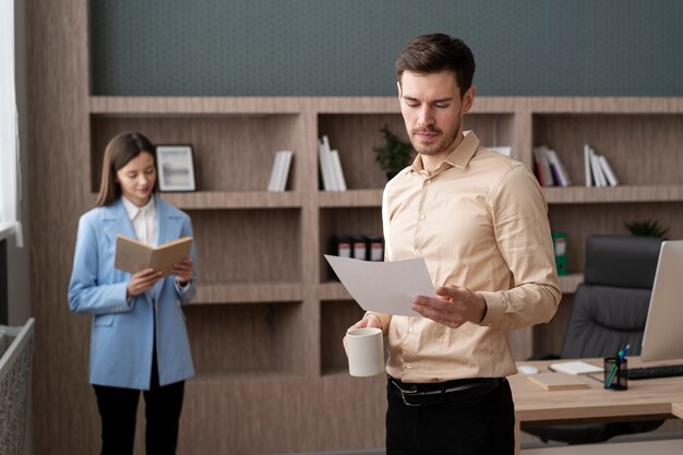 Donna e uomo di tiro medio al lavoro