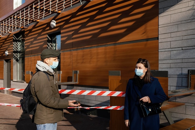 Donna e uomo sulla strada che indossa la maschera