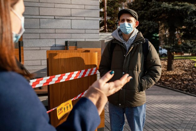 Donna e uomo sulla strada che indossa la maschera