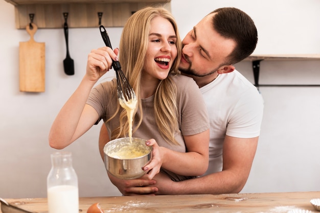 Donna ed uomo sorridenti che cucinano insieme