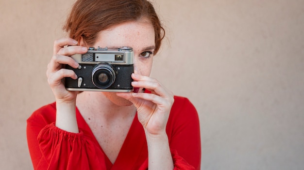 Donna elegante che usando una macchina fotografica d'epoca