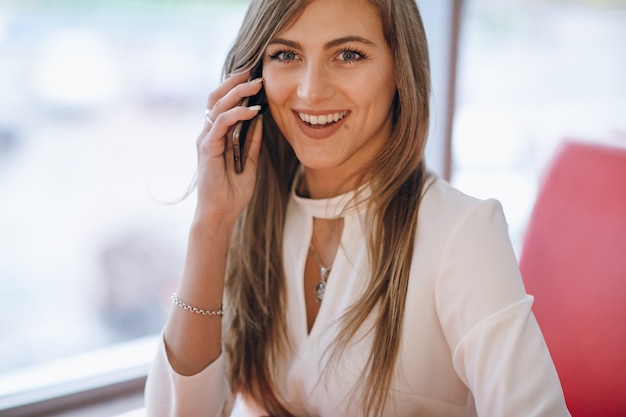 Donna elegante con volto sorridente, parlando al telefono