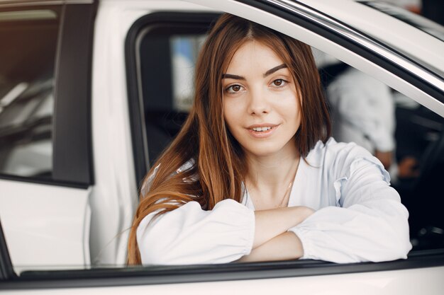 Donna elegante e alla moda in un salone di auto