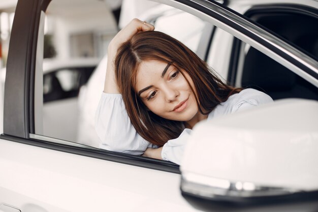 Donna elegante e alla moda in un salone di auto