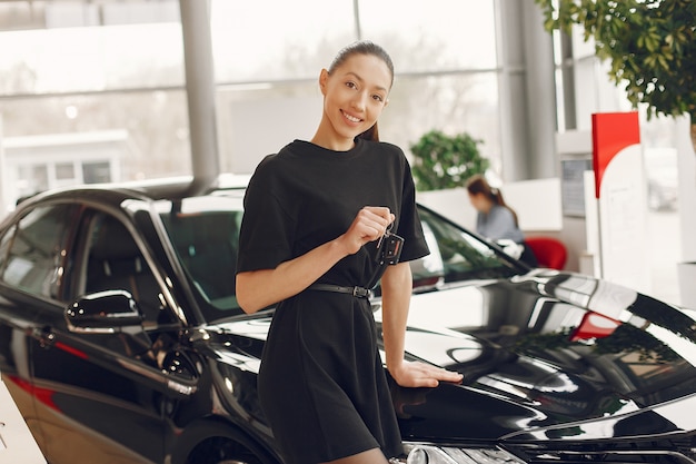 Donna elegante e alla moda in un salone di auto