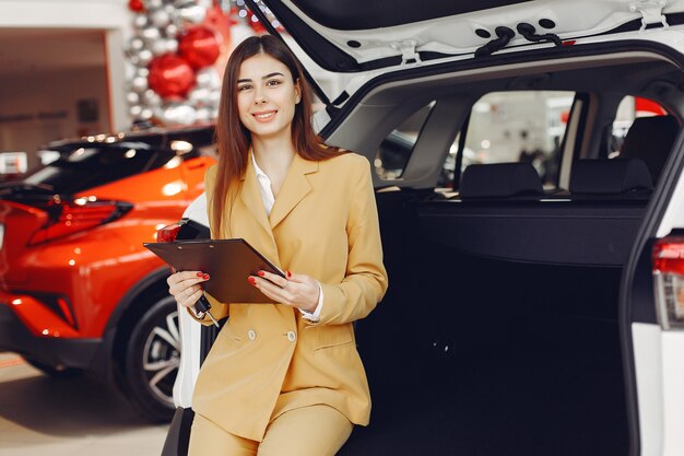 Donna elegante e alla moda in un salone di auto