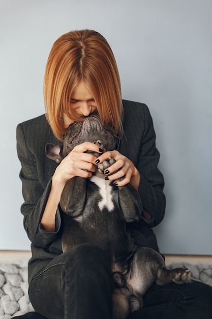 Donna elegante in un abito nero con bulldog nero