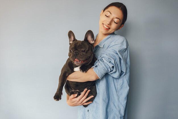 Donna elegante in una camicia blu con bulldog nero