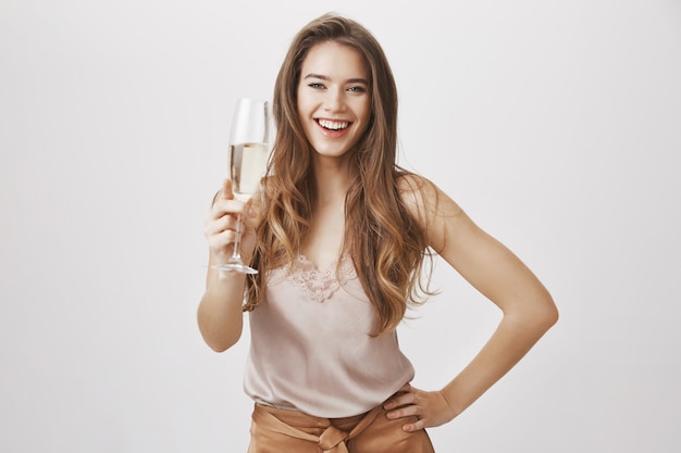 Donna elegante sorridente con un bicchiere di champagne