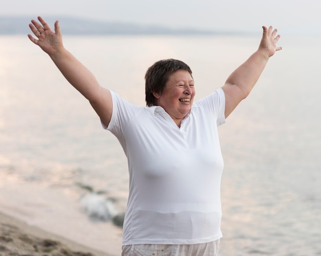 Donna emozionante del colpo medio alla spiaggia