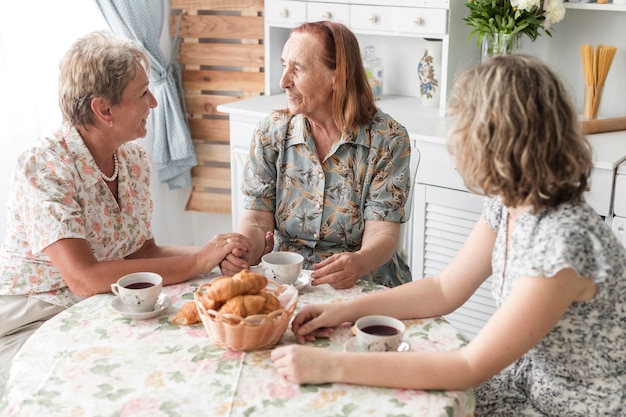 Donna facendo colazione con la madre e la nonna a casa