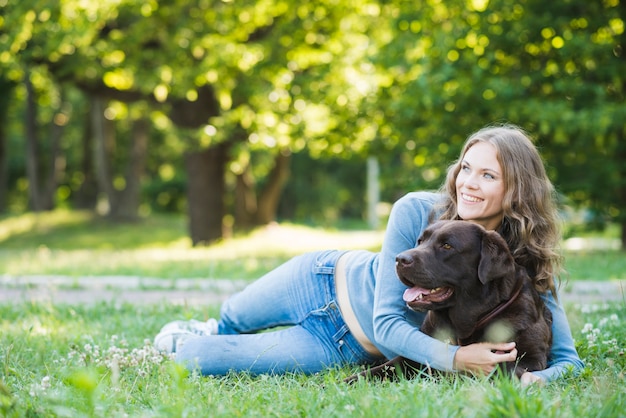 Donna felice che abbraccia il suo cane in giardino