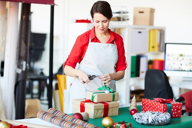 Donna felice che avvolge regali o regali di Natale