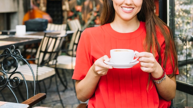 Donna felice che beve caffè nel caf�