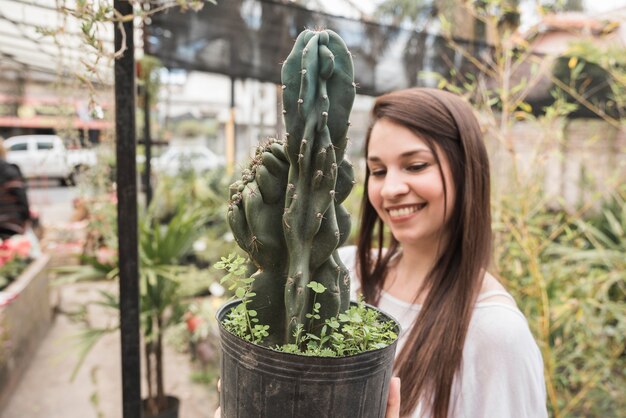 Donna felice che esamina pianta in vaso succulente