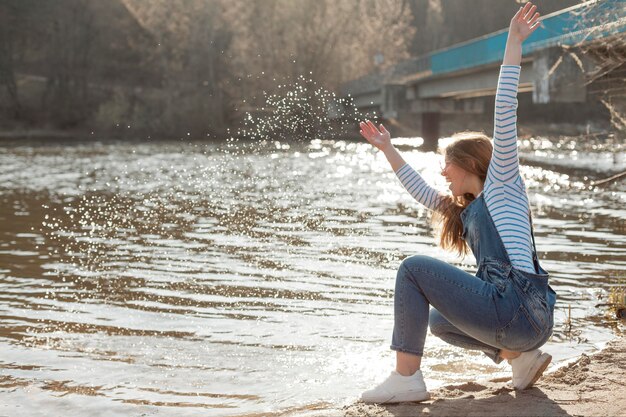 Donna felice che gode del suo tempo in riva al lago