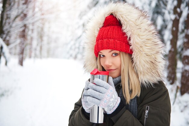 Donna felice che indossa vestiti caldi, bere tè caldo