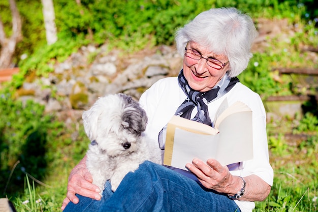 Donna felice che legge con il suo cane