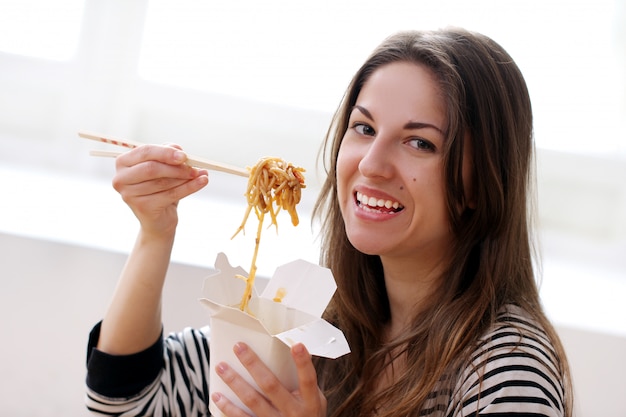 Donna felice che mangia le tagliatelle