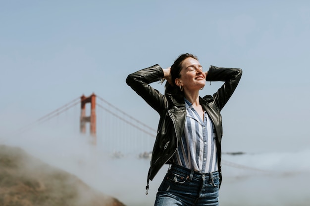 Donna felice che posa per una foto a golden gate bridge, San Francisco