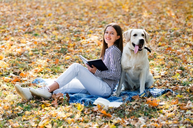 Donna felice che propone con il suo labrador